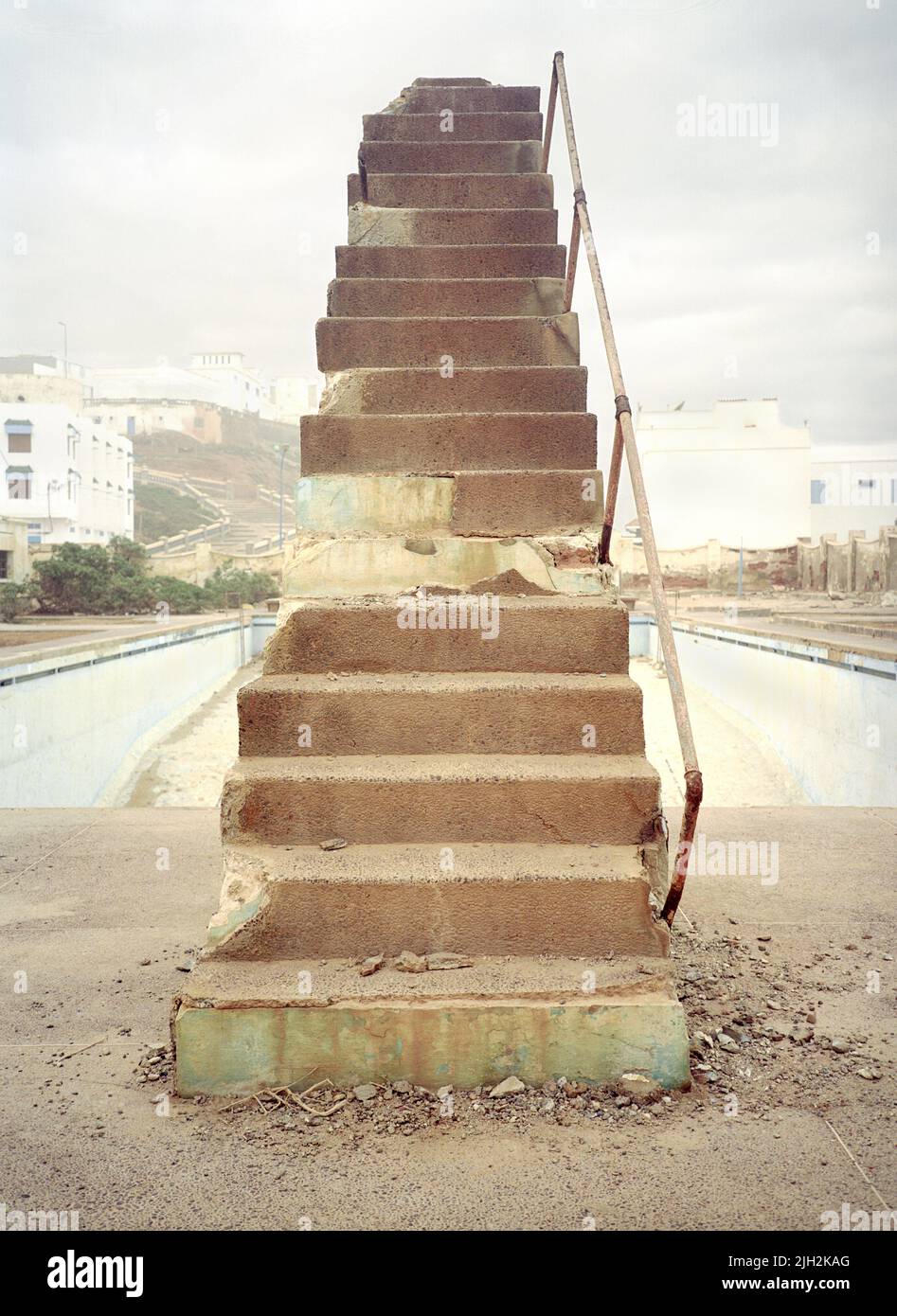 Steps to a decaying stone diving board. Abondoned public pool. Sidi Ifni , South West Coast of Morocco. North Africa. Stock Photo