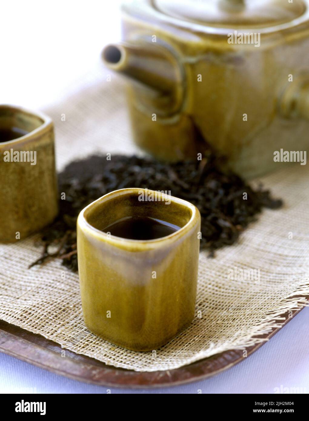 Herbal black  tea leaves with teacups and teapot Stock Photo