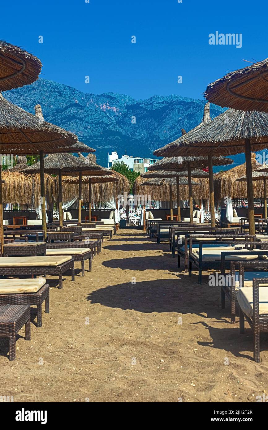 View of deck chairs and umbrellas on the sandy beach of Kemer, Turkey. Stock Photo