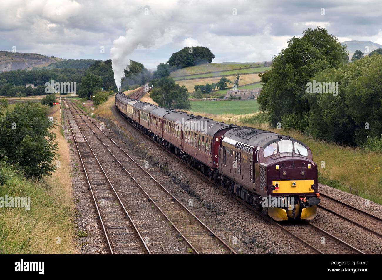 The Dalesman steam special at Settle Junction, heading for Carlisle. The steam loco is seen starting the climb, assisted by a diesel loco on the rear. Stock Photo