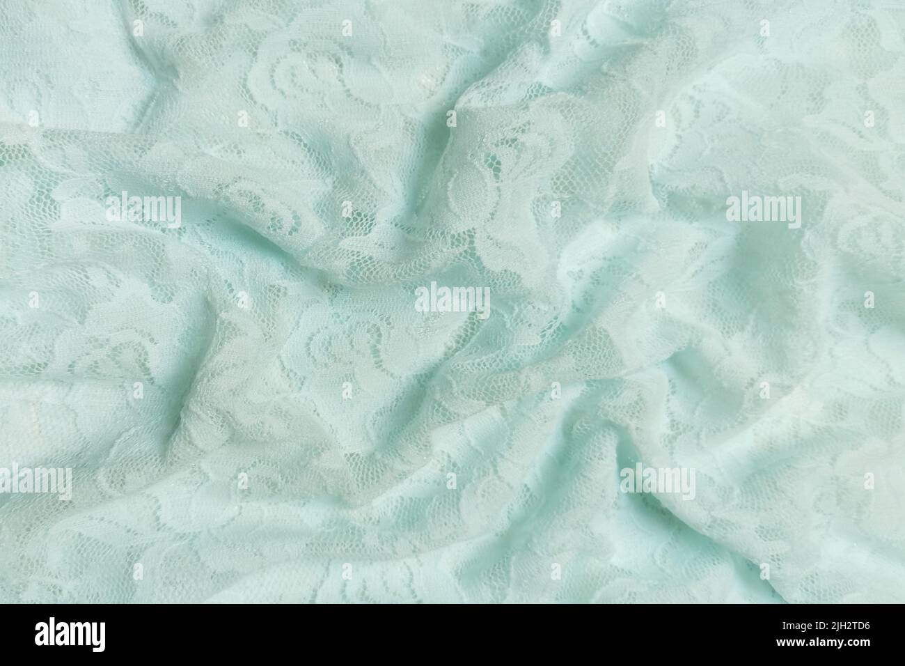 Mint or green guipure with roses. Crumpled or wavy fabric texture background. Abstract linen cloth soft waves. Natural yarn. Smooth elegant luxury Stock Photo