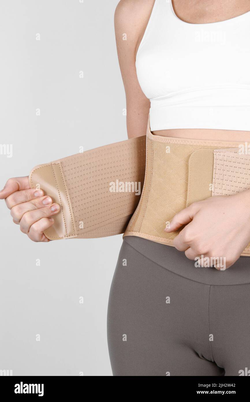 Orthopedic lumbar corset on the human body. Back brace, waist support belt for back. Posture Corrector For Back Clavicle Spine. Post-operative Hernia Stock Photo
