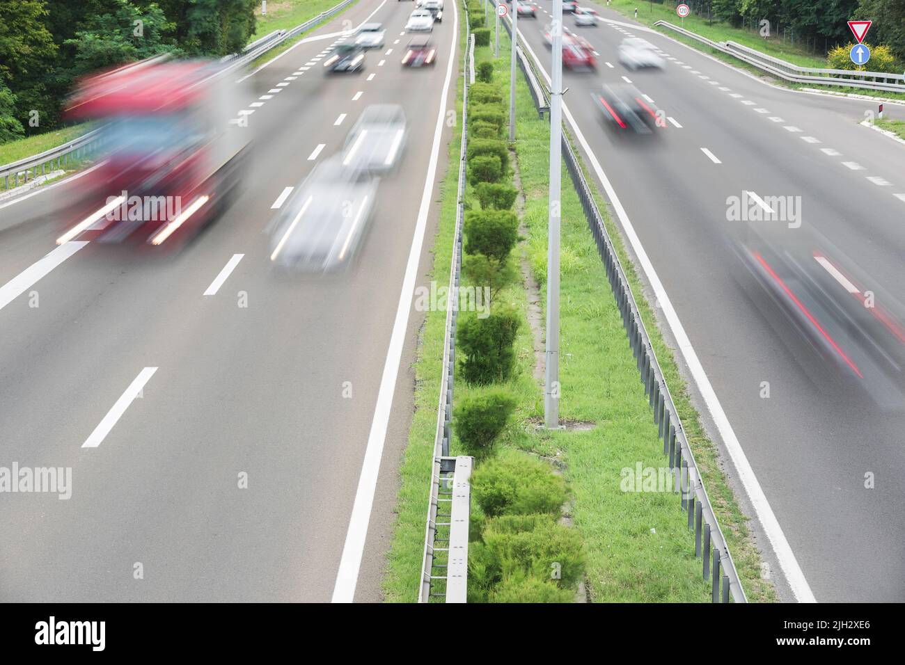 Highway traffic. Cargo truck and cars on the road, truck transportation and car travel.   View of multilane highway in summer Stock Photo