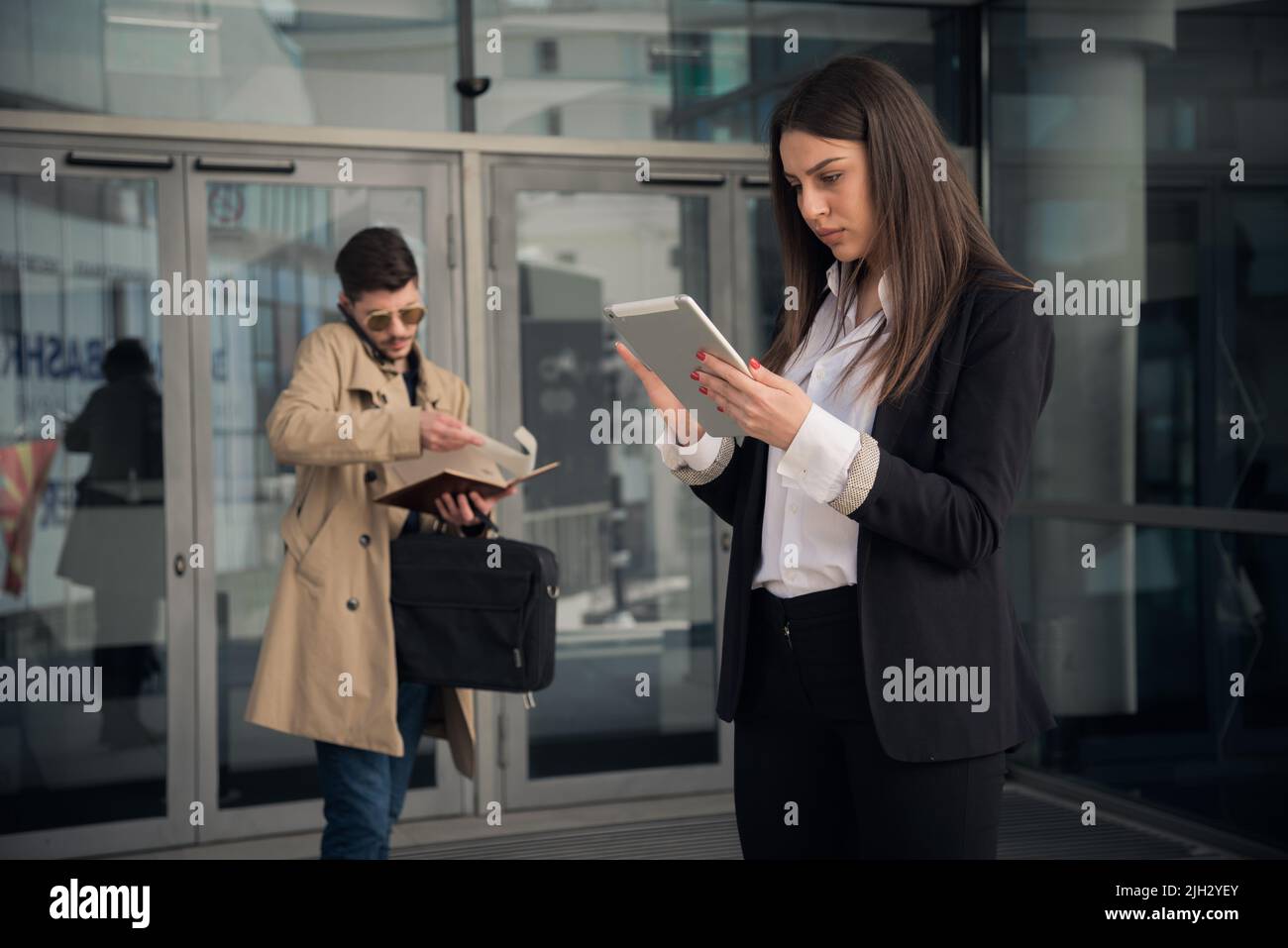 Assistent is taking notes from his phone call while his boss is looking at the plans Stock Photo