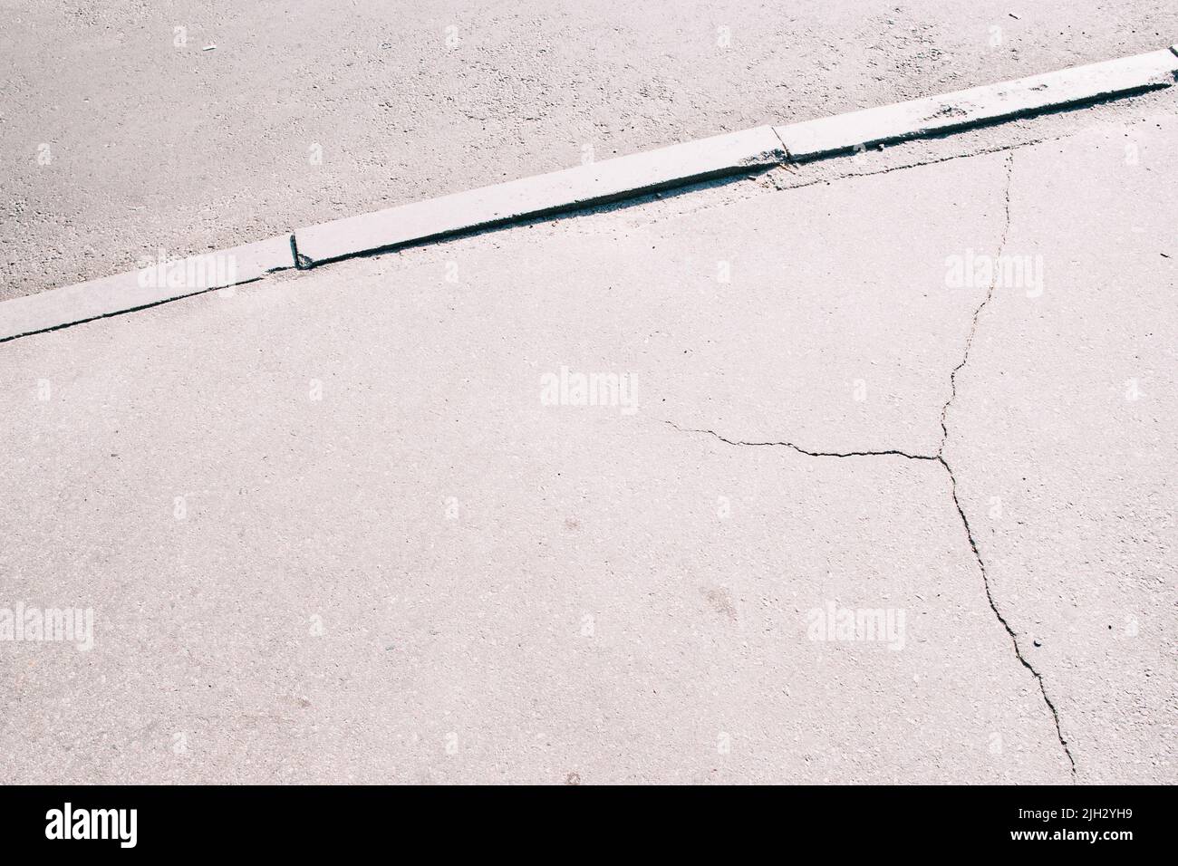 Sidewalk asphalt road with cracks Stock Photo