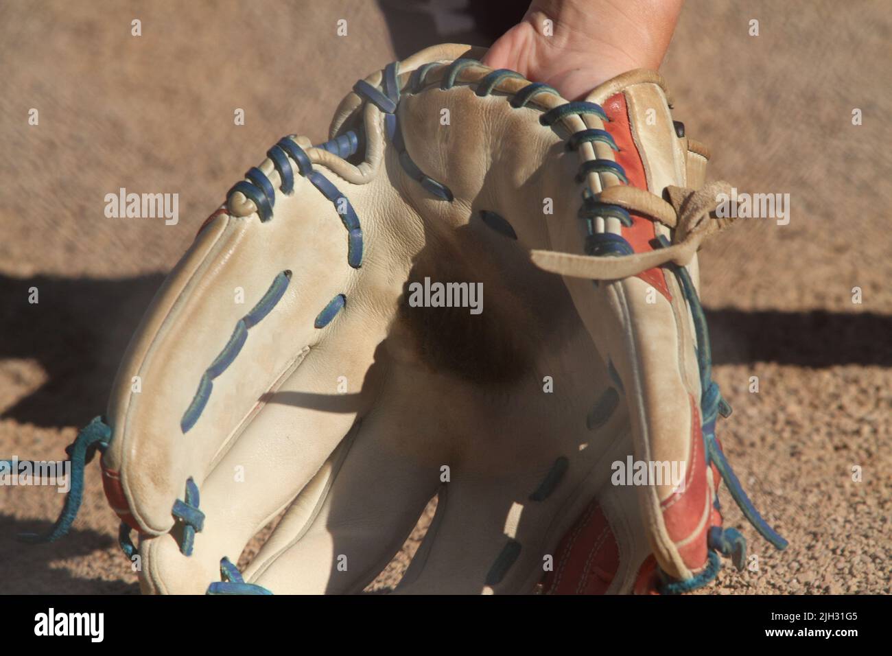 Closeup of a softball player's glove ready to field a ground ball. Stock Photo