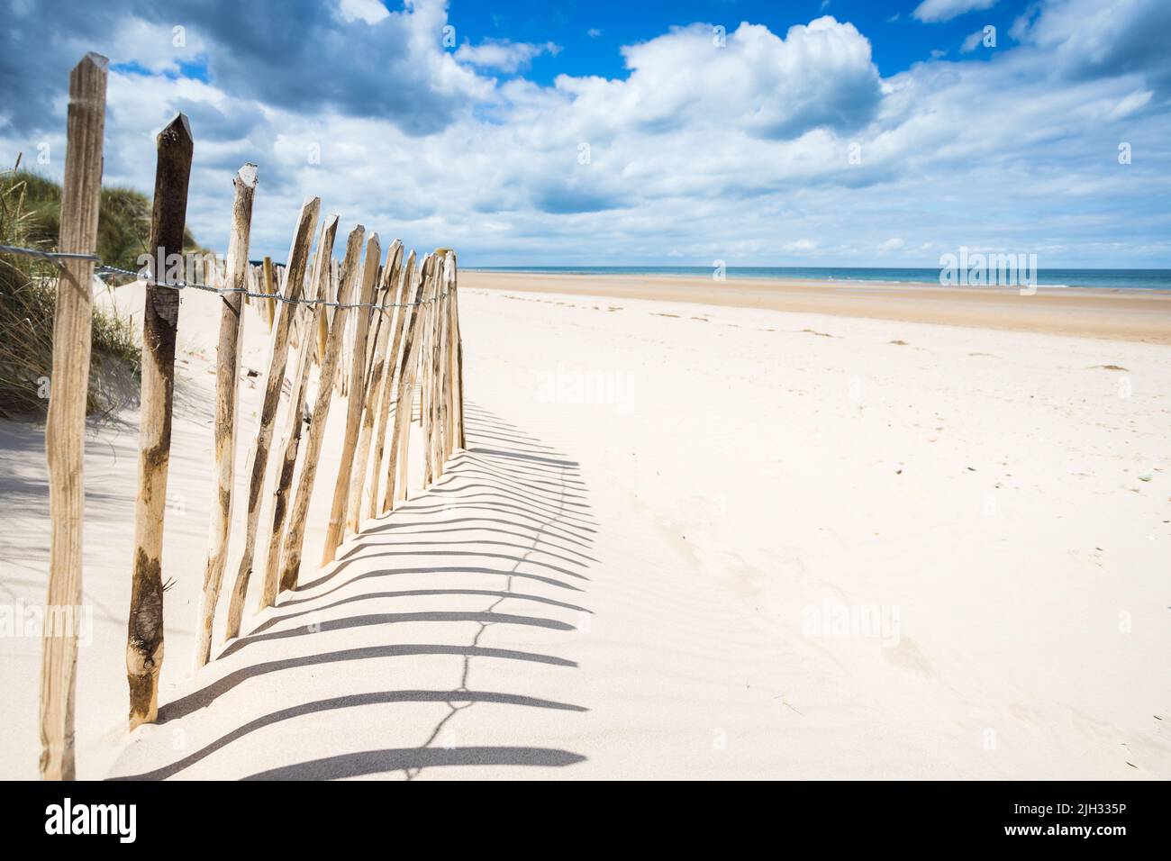 Beach fences on the coast at Holkham cast shadows on the beatiful sand along the North Norfolk coast. Stock Photo