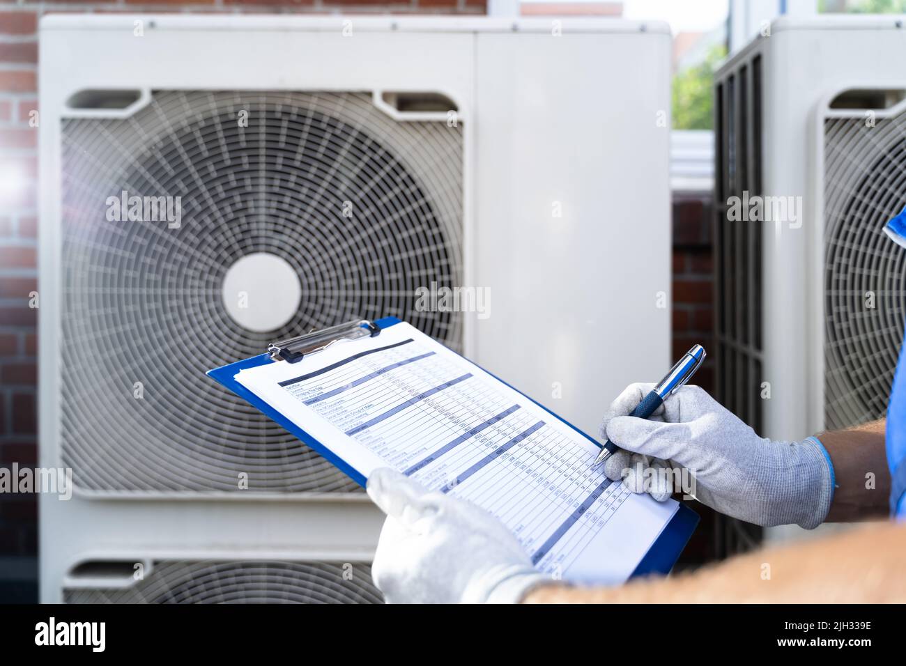 Two Electricians Men Wearing Safety Jackets Checking Air Conditioning