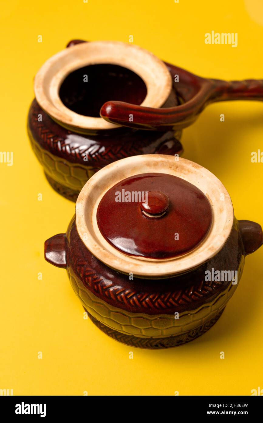clay pot for hot dishes and pot holder on a yellow background Stock