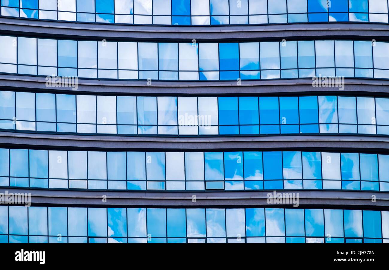Reflection of sky in glass facade of office building Stock Photo - Alamy