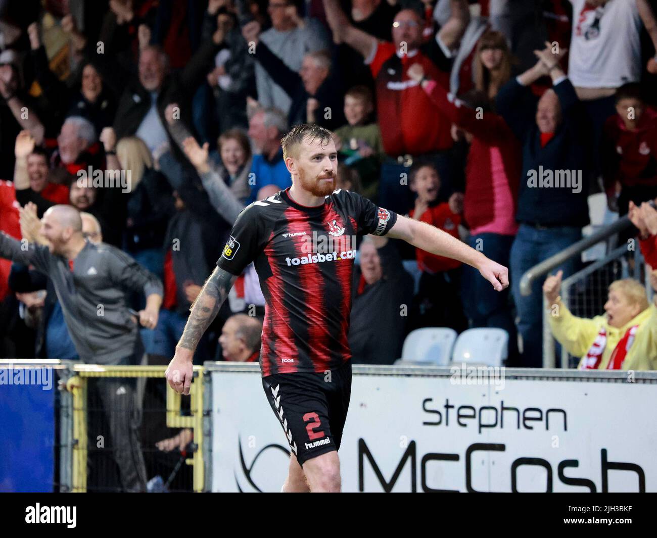 Seaview, Belfast, Northern Ireland, UK. 14 July 2022. UEFA Conference League First Qualifying Round  (second leg) – Crusaders v Magpies. Action from tonight's game at Seaview (Crusaders in red/black). Credit: Crusaders captain Billy Joe Burns (2) scoring and celebrating the winning goal. CAZIMB/Alamy Live News. Stock Photo