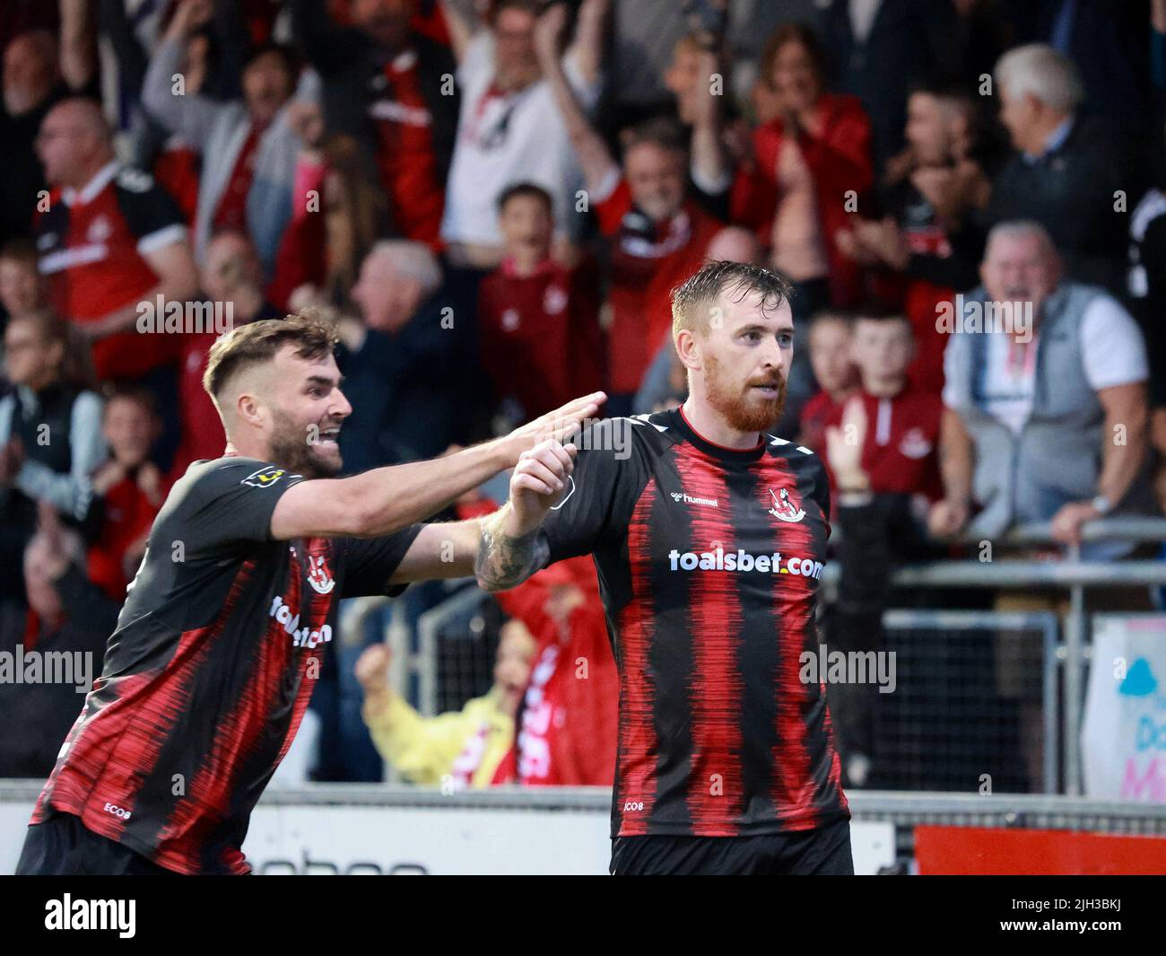 Seaview, Belfast, Northern Ireland, UK. 14 July 2022. UEFA Conference League First Qualifying Round  (second leg) – Crusaders v Magpies. Action from tonight's game at Seaview (Crusaders in red/black). Credit: Crusaders captain Billy Joe Burns (2) scoring and celebrating the winning goal. CAZIMB/Alamy Live News. Stock Photo