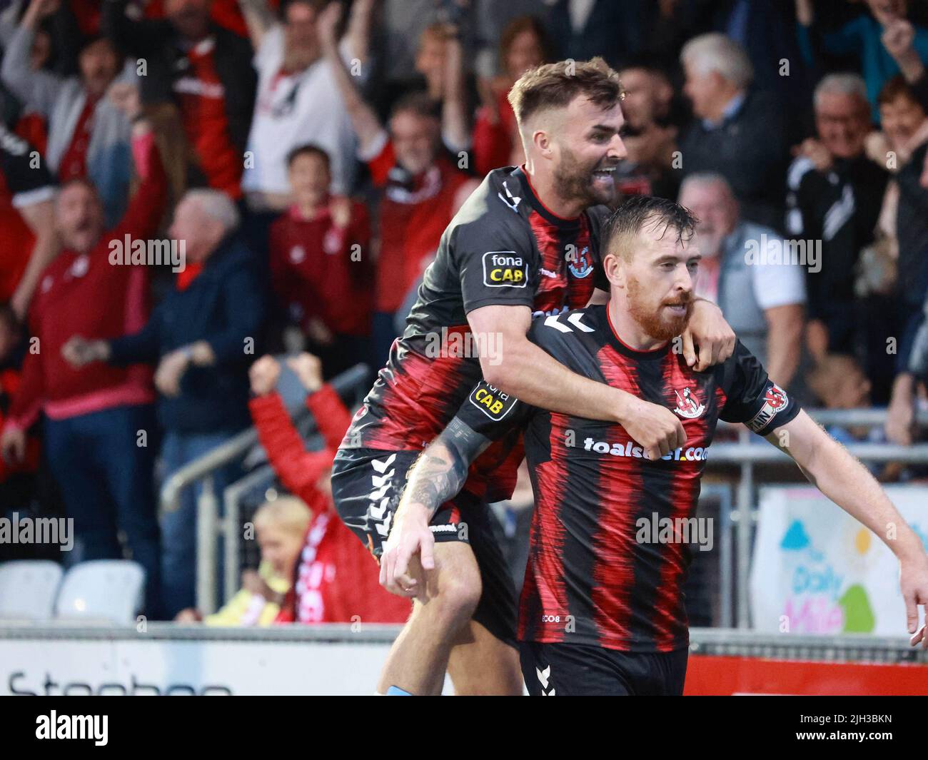 Seaview, Belfast, Northern Ireland, UK. 14 July 2022. UEFA Conference League First Qualifying Round  (second leg) – Crusaders v Magpies. Action from tonight's game at Seaview (Crusaders in red/black). Credit: Crusaders captain Billy Joe Burns (2) scoring and celebrating the winning goal. CAZIMB/Alamy Live News. Stock Photo