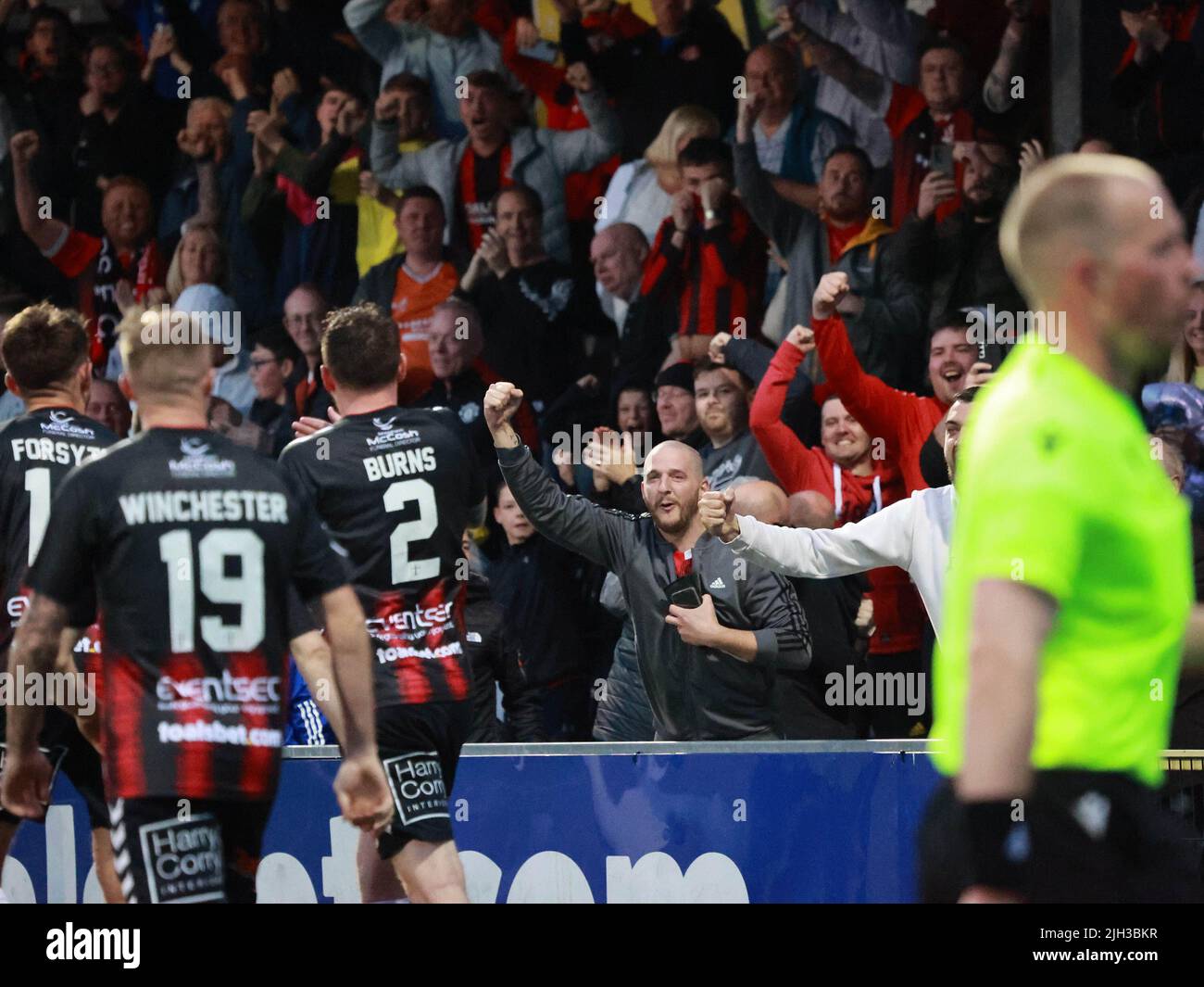 Seaview, Belfast, Northern Ireland, UK. 14 July 2022. UEFA Conference League First Qualifying Round  (second leg) – Crusaders v Magpies. Action from tonight's game at Seaview (Crusaders in red/black). Credit: Crusaders captain Billy Joe Burns (2) scoring and celebrating the winning goal. CAZIMB/Alamy Live News. Stock Photo