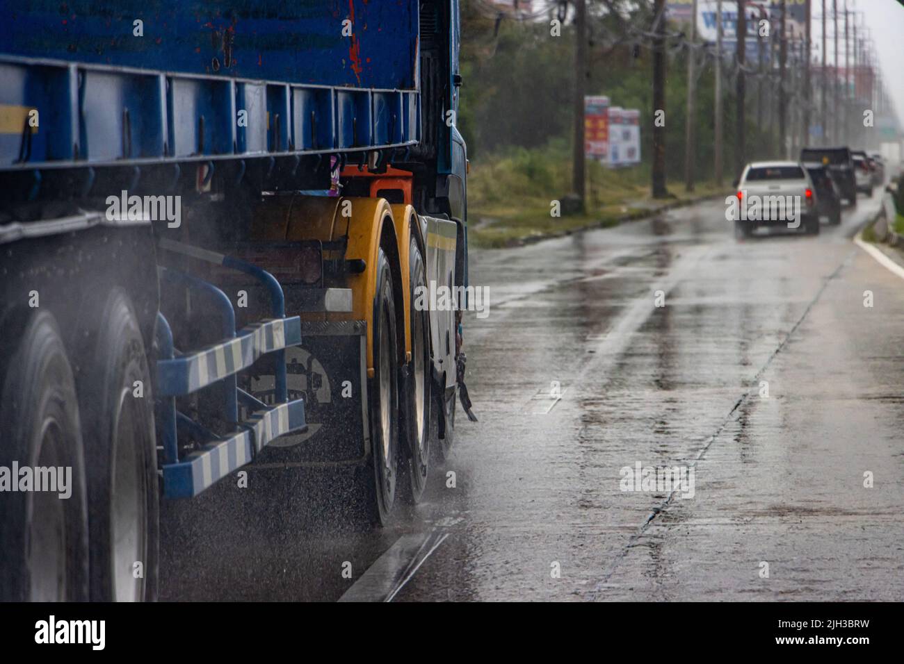 The truck drives on a wet road behind a convoy of cars Stock Photo