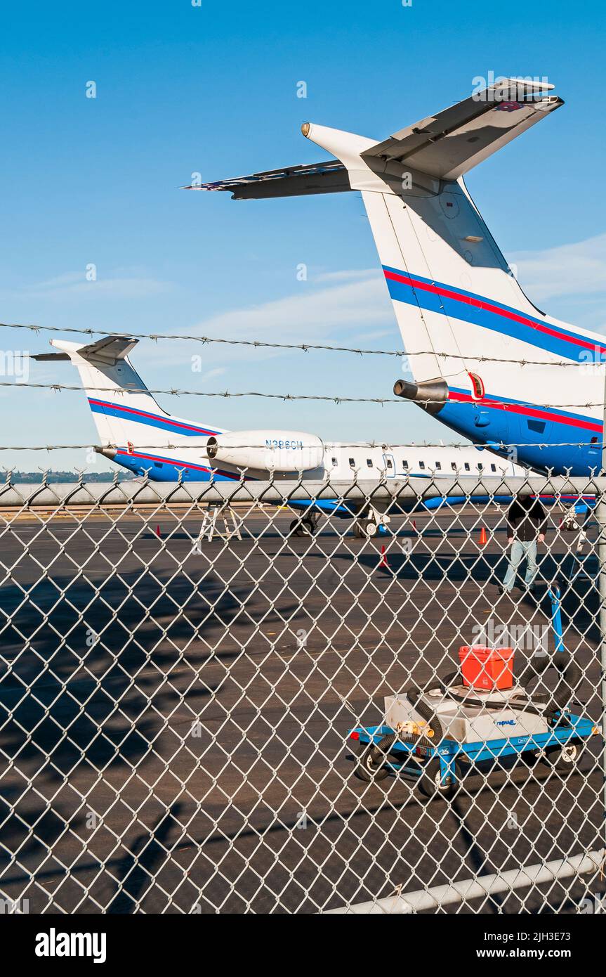 Large passenger jet airplanes inside the fence, on the tarmac of the