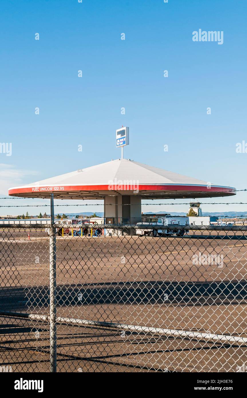 A covered fueling station inside the fence, on the tarmac of the
