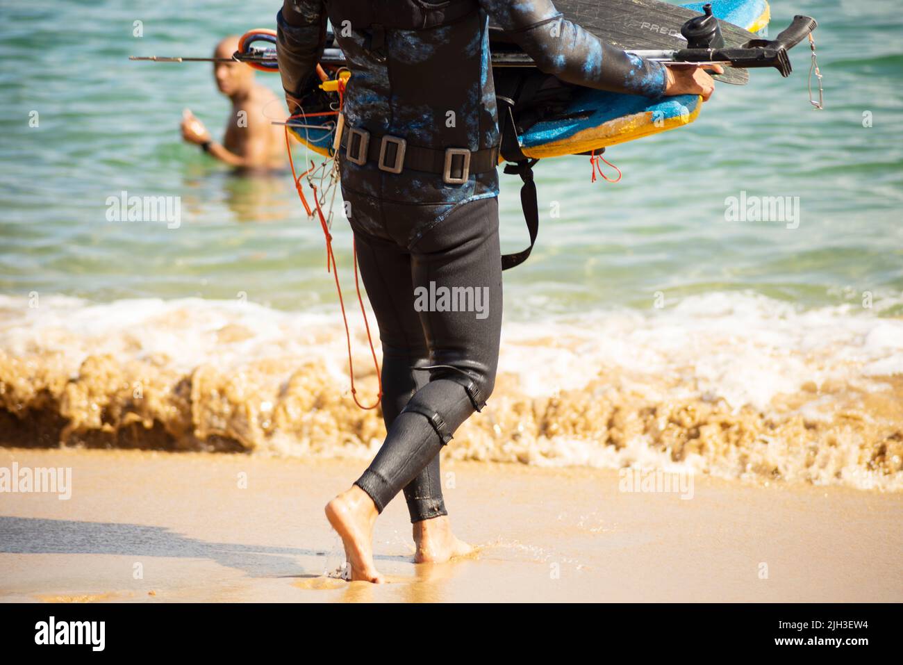 Man entering the sea with diving equipment. Porto da Barra beach, in Salvador, state of Bahia, Brazil. Stock Photo