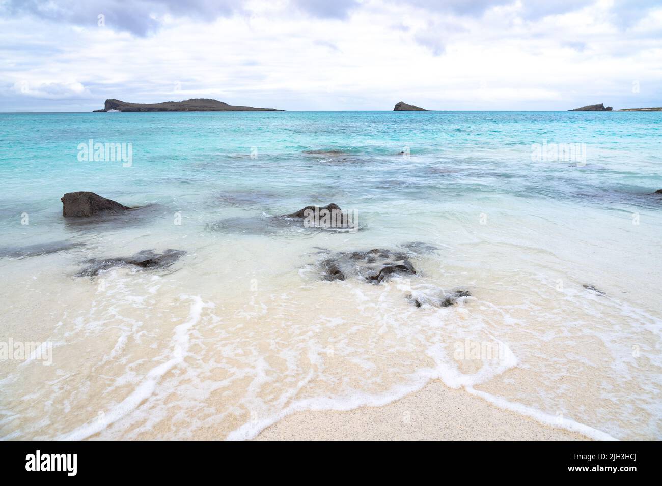 Beautiful white sand beach and blue waters in the Galapagos Stock Photo