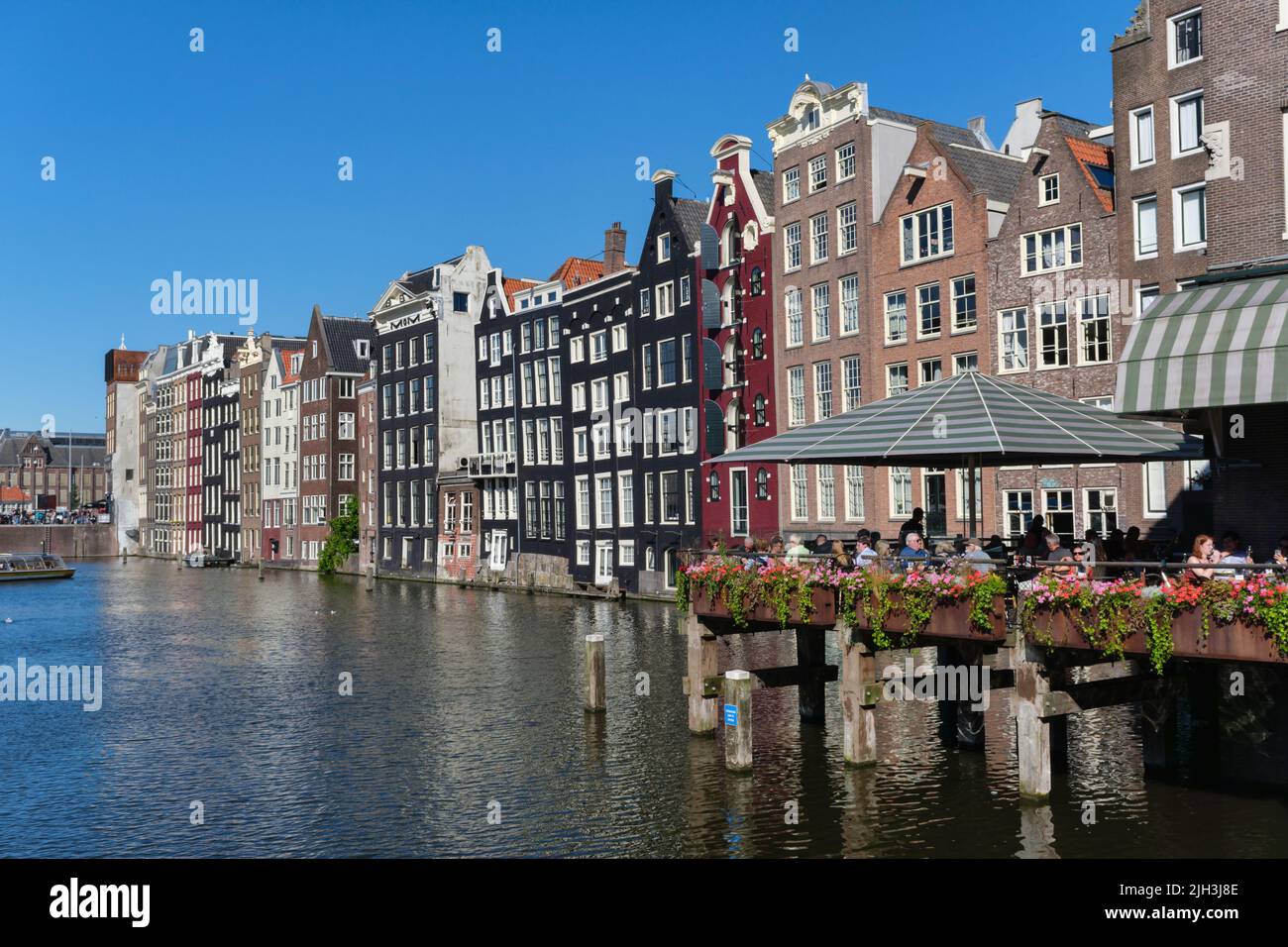 Amsterdam, The Netherlands - 22 June 2022: People eating at a restaurant at Damrak waterfront Stock Photo