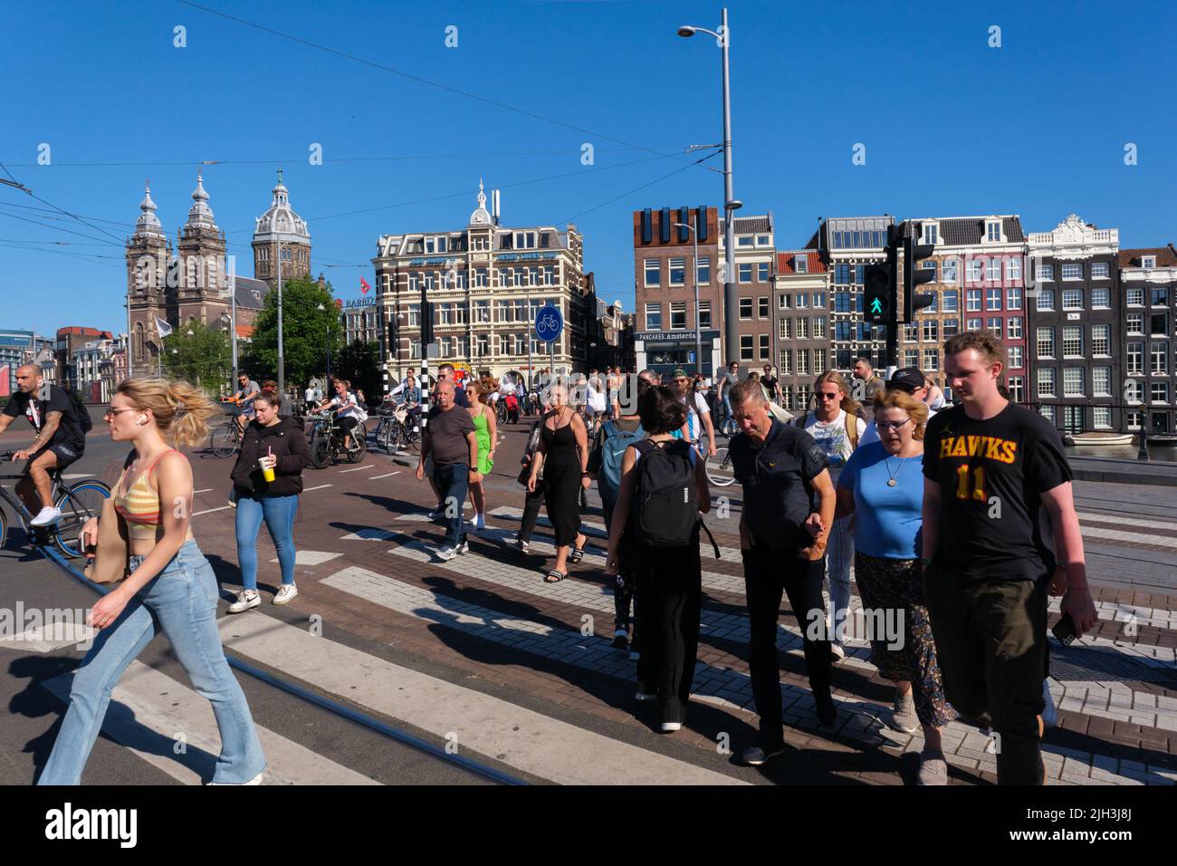 Amsterdam, Netherlands - 22 June 2022: Many people crossing the street in Amsterdam Stock Photo