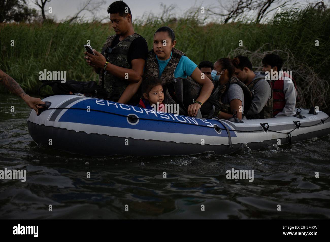 Asylum seeking migrants, including three year old Analia from Nicaragua, are smuggled across the Rio Bravo del Norte, also known as the Rio Grande river, into the United States from Ciudad Miguel Aleman, Mexico July 13, 2022. REUTERS/Adrees Latif Stock Photo