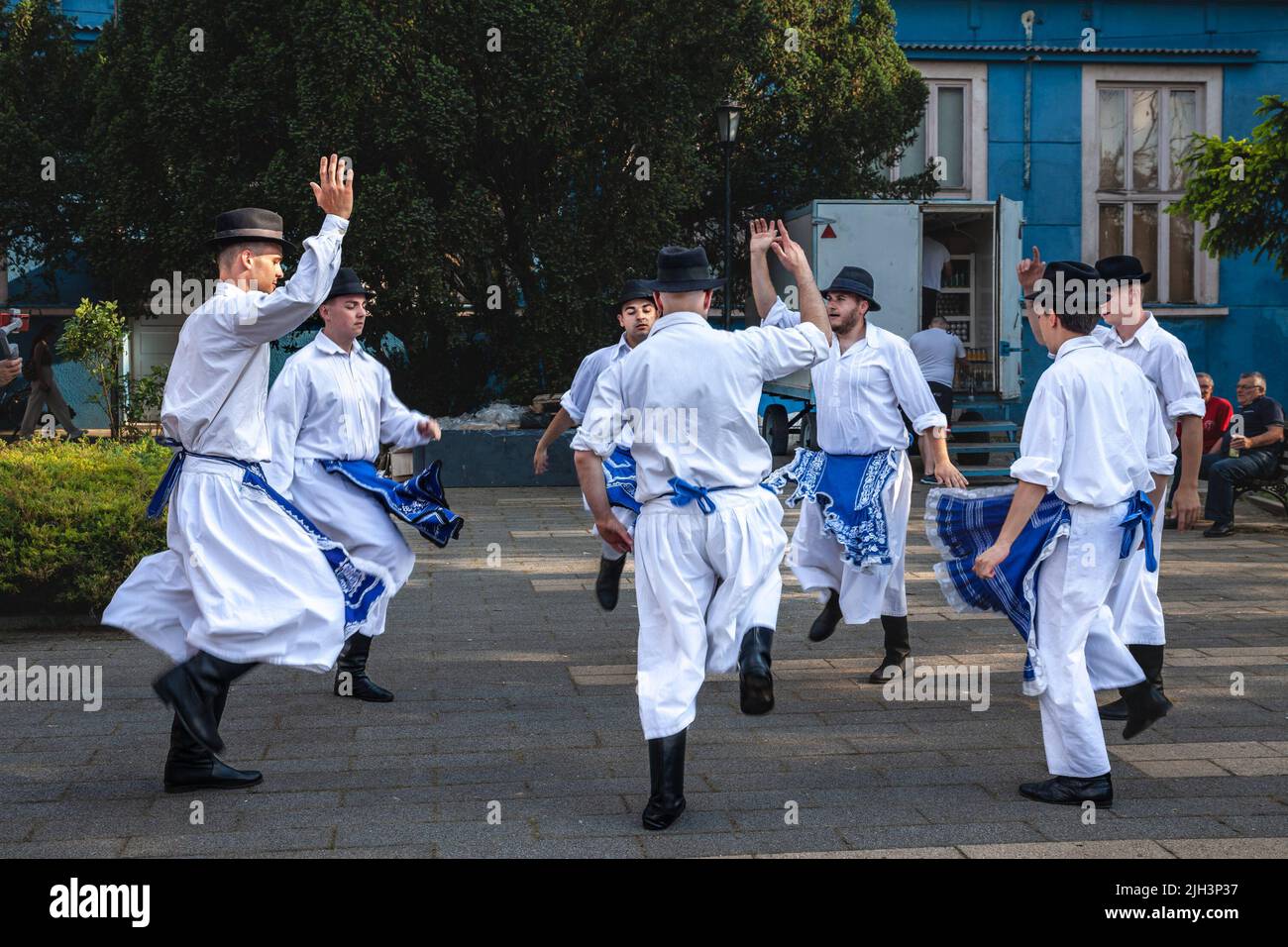 Picture of a group of men, slovaks, wearing a traditional folk slovakian costume in Kovacica, Serbia while dancing traditional folk dances. According Stock Photo