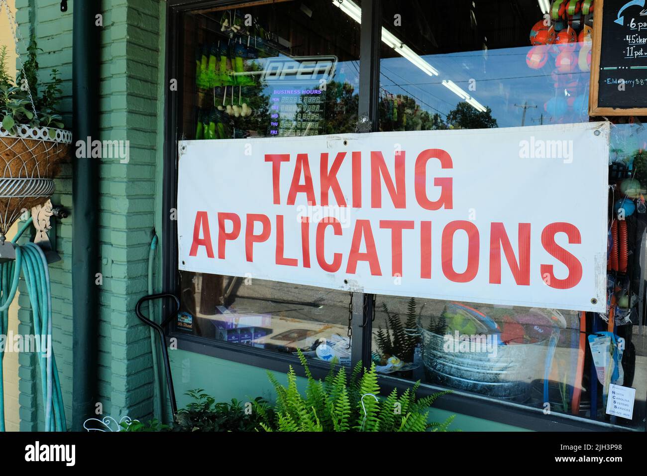 Taking applications sign on a storefront window in the United States; employers seeking workers during the 2022 great resignation; economic growth. Stock Photo