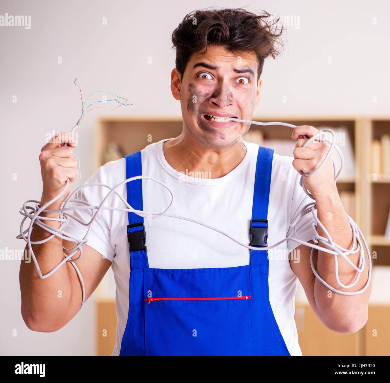 The funny man doing electrical repairs at home Stock Photo