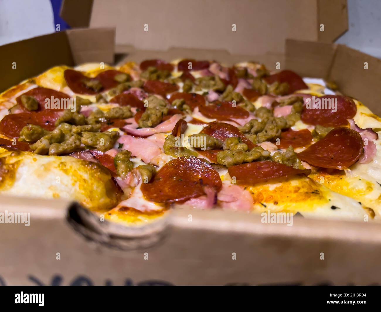 Close up, selective focus on a meat lovers pizza inside a cardboard delivery box Stock Photo Alamy