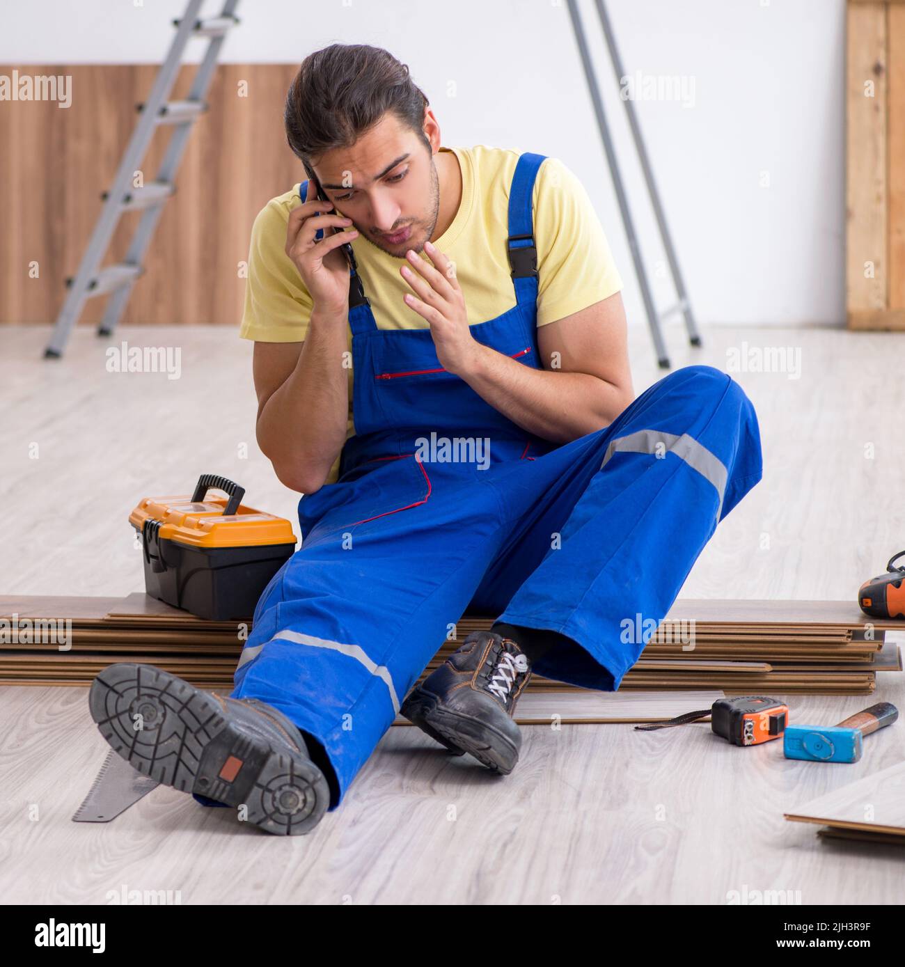 The young male contractor working indoors Stock Photo - Alamy