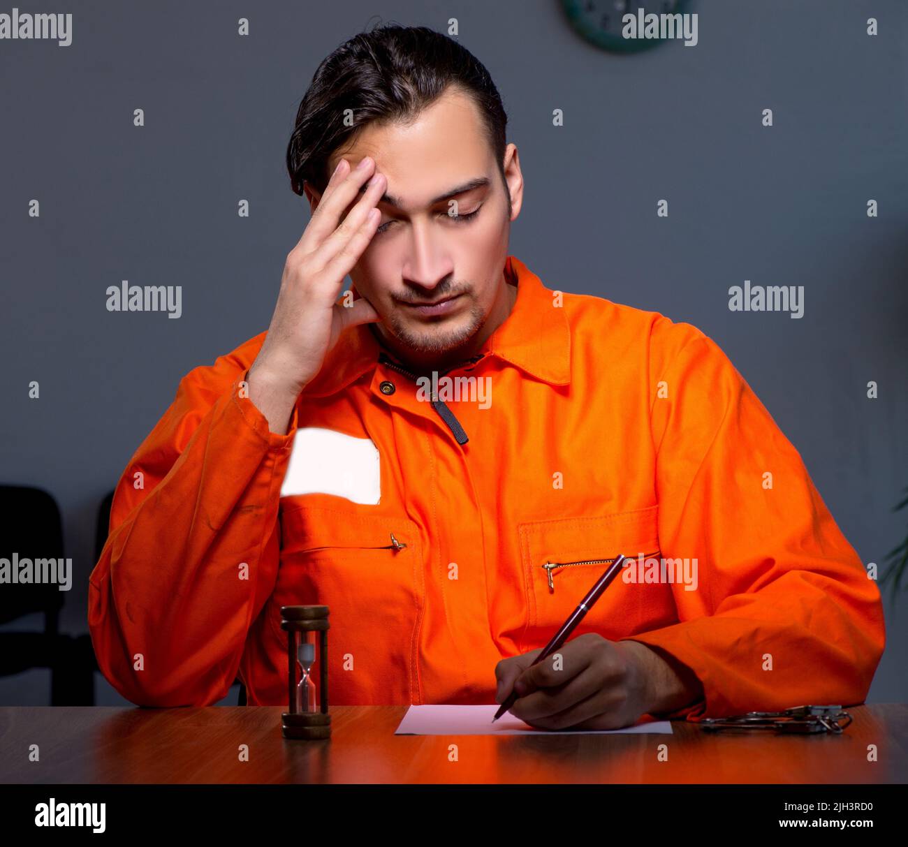 The young convict man sitting in dark room Stock Photo