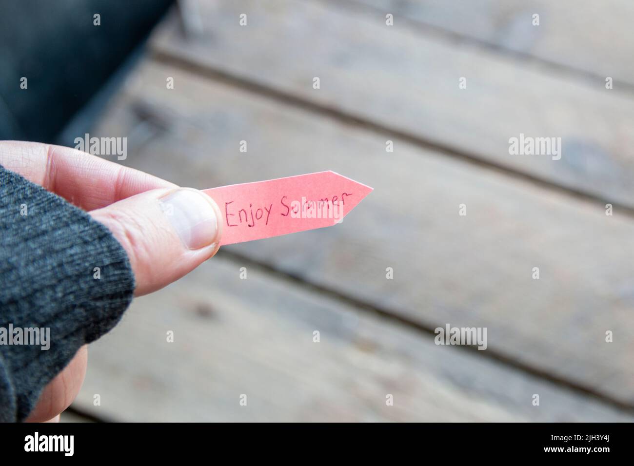 Enjoy summer concept. A man holds a pointer with an inscription. Stock Photo