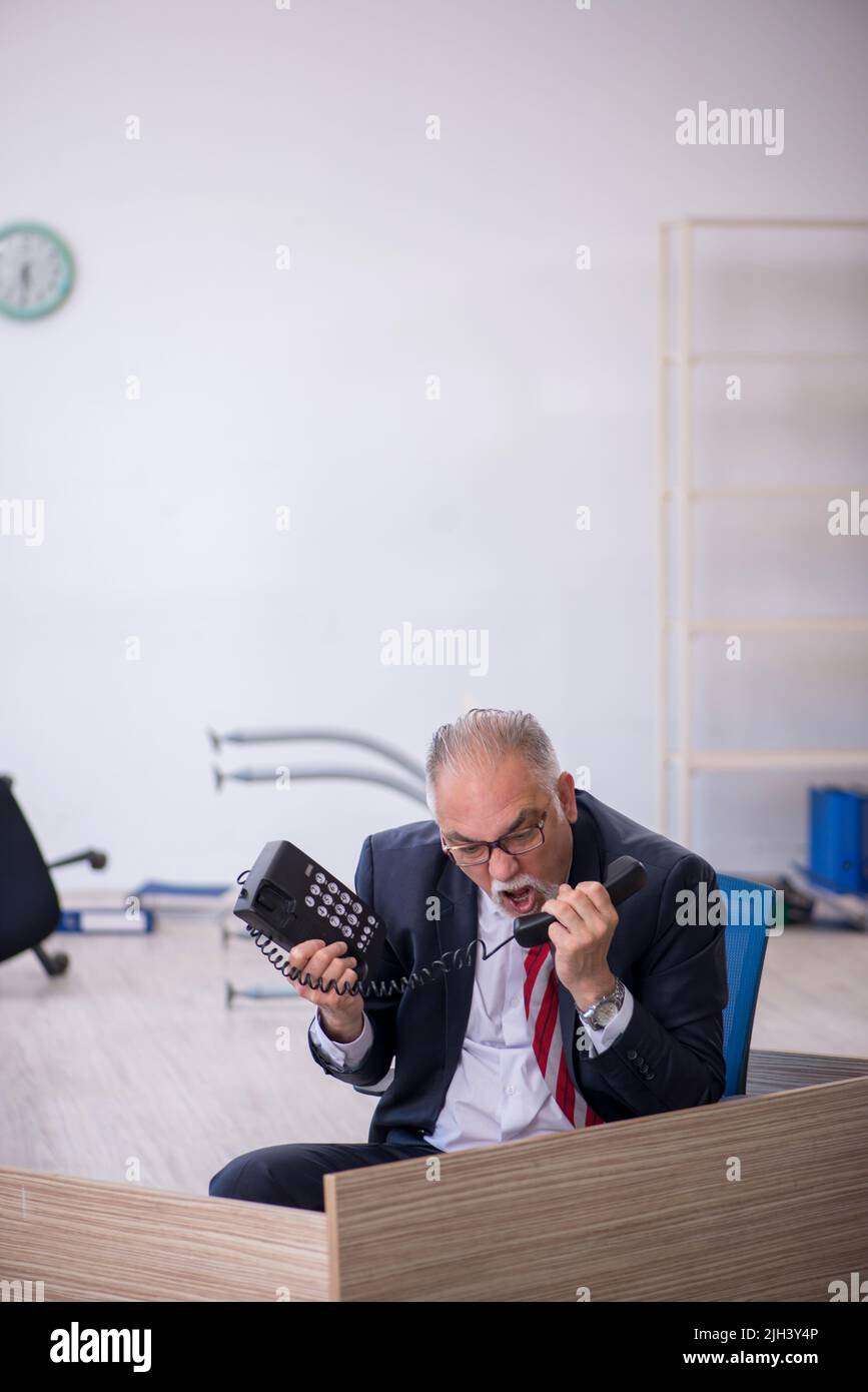 Old businessman employee working overtime at workplace Stock Photo - Alamy