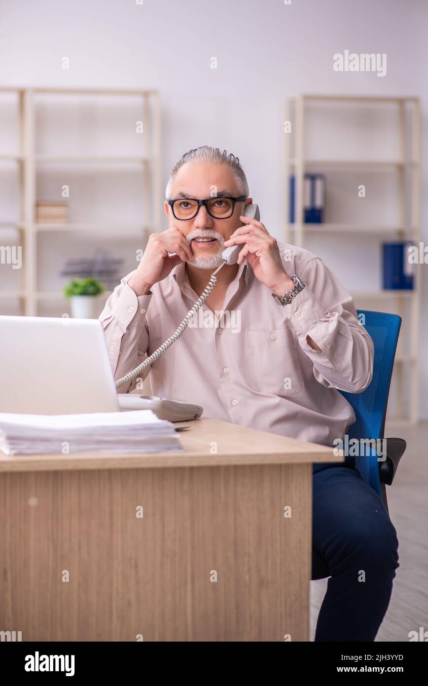 Old businessman employee working at workplace Stock Photo - Alamy