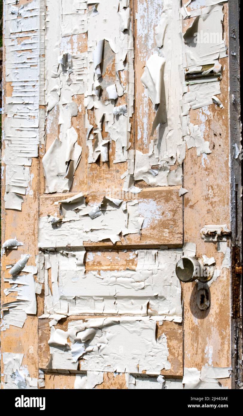 An old wooden door is covered in peeling paint Stock Photo