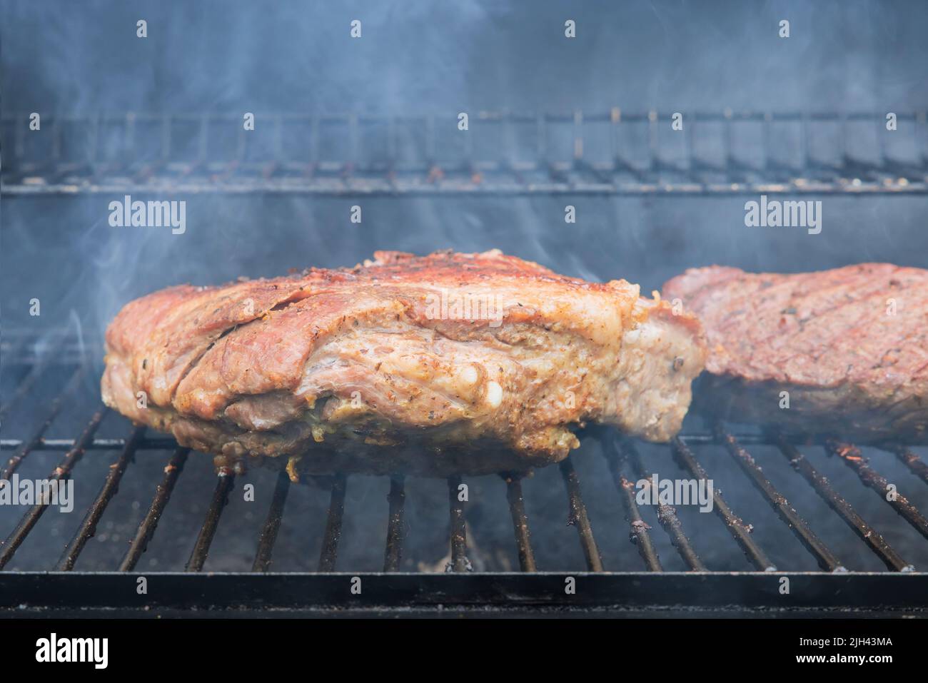 This is a typical American food with grilled beef steaks and pork ribs on a hot BBQ Stock Photo
