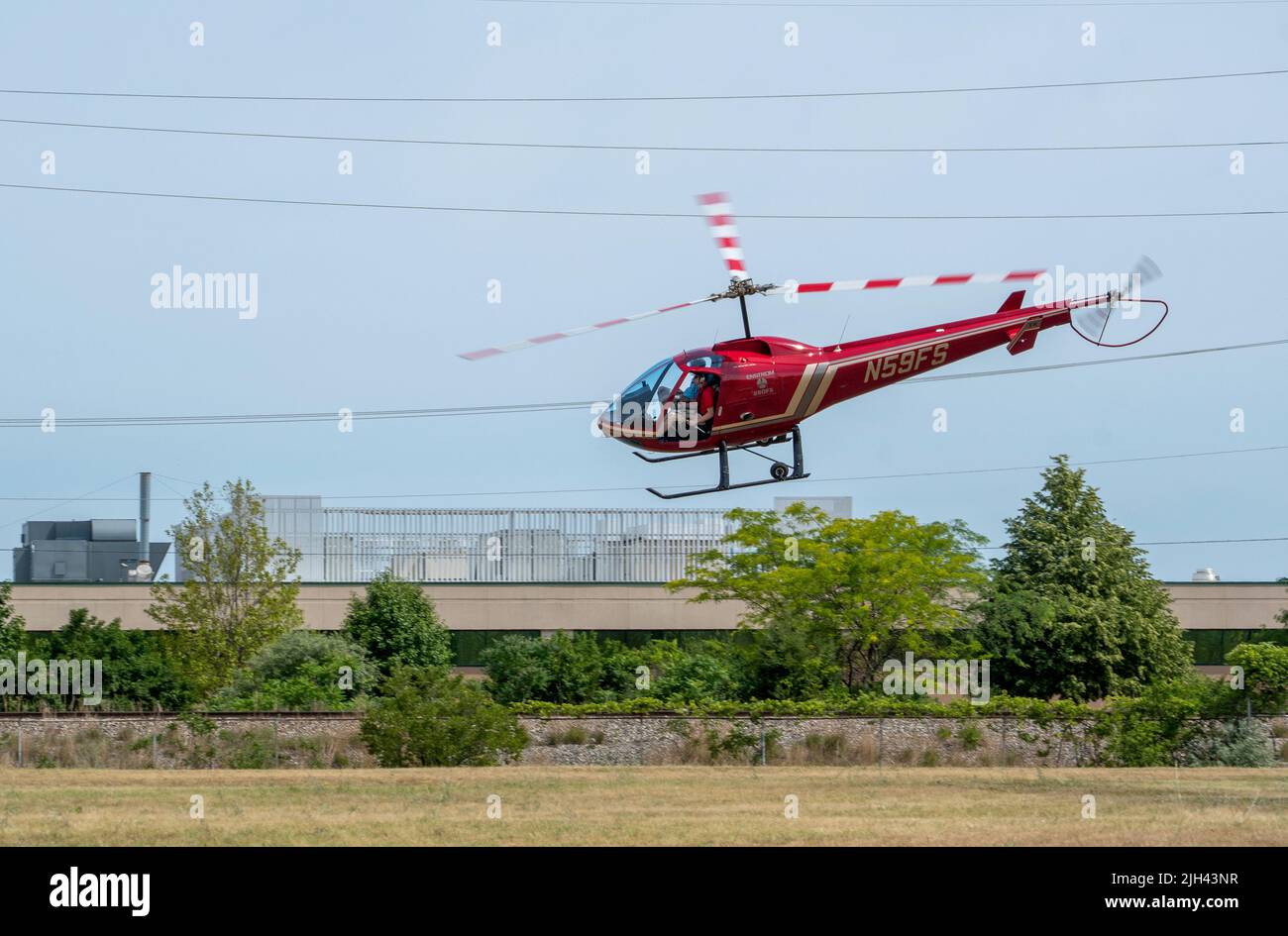 June 20, 2021 St Joseph MI USA; A red helicopter banks air takes off with a passenger during an air show event in Michigan Stock Photo