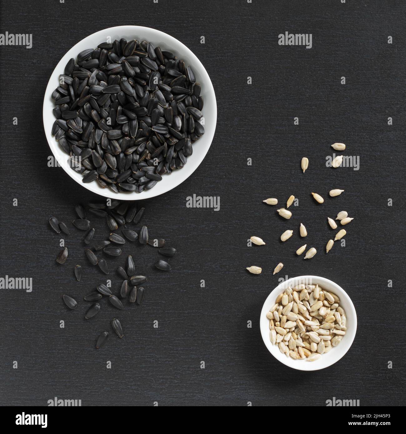 Sunflower seeds peeled and unpeeled on black stone background, top view ...