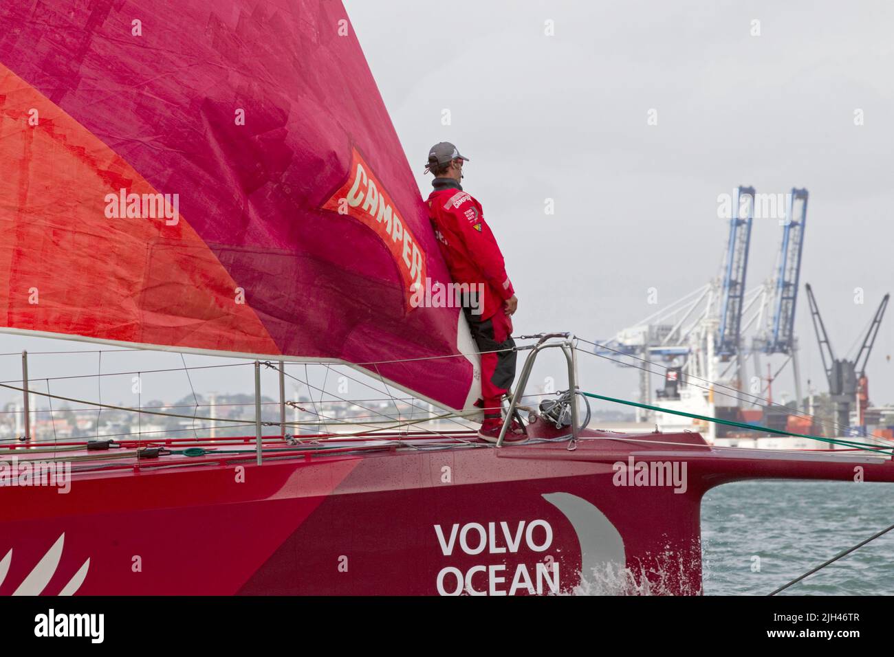 Camper with Emirates Team New Zealand bowman Daryl Wislang keeps watch as the team compete in the in-port race as part of the Volvo Ocean Race Stock Photo