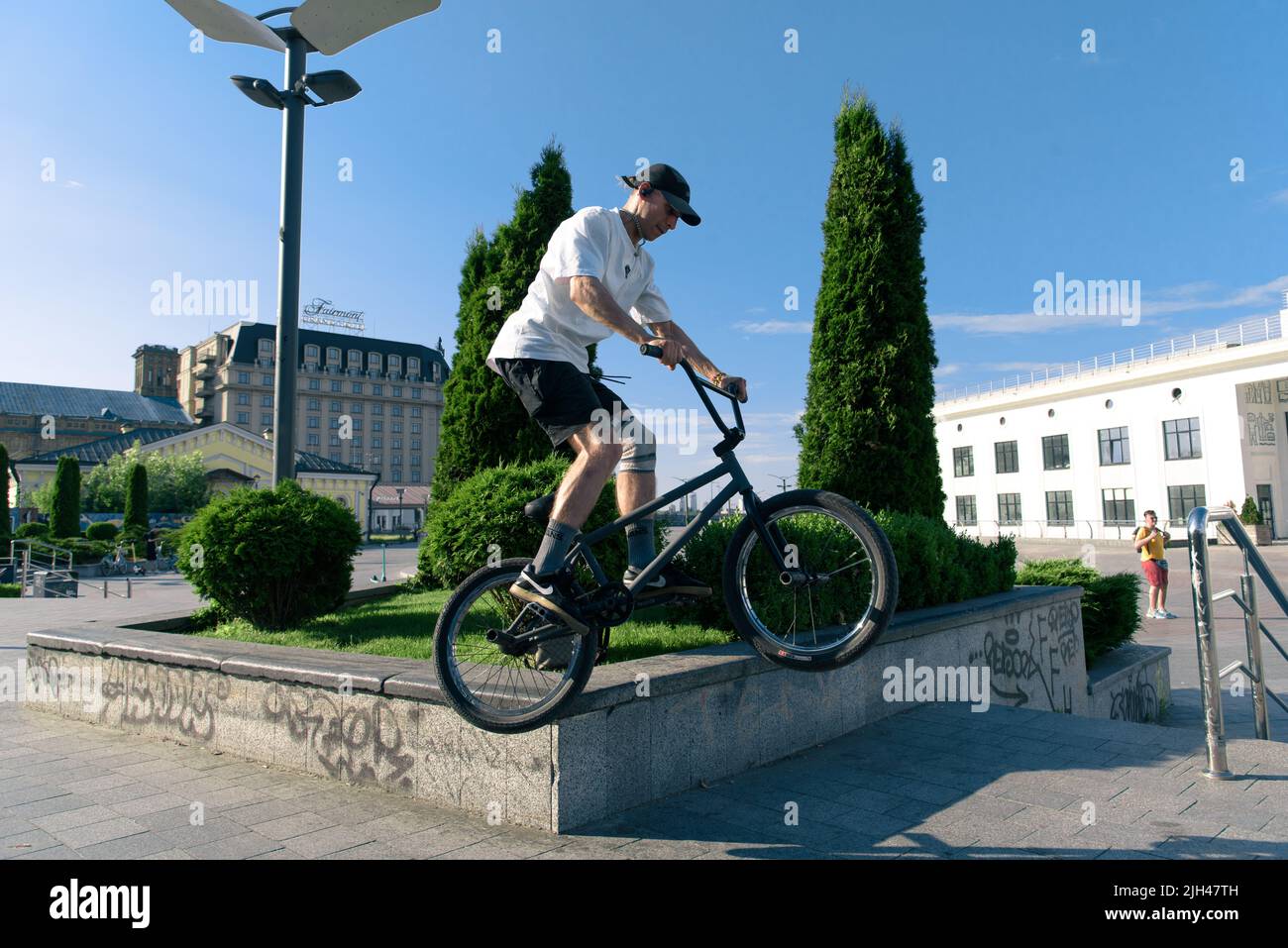 Kyiv, Ukraine - June 15, 2022: Contract Square. Bmx biker performing tricks and stunts training in city park. Jump on bmx bike in action Stock Photo