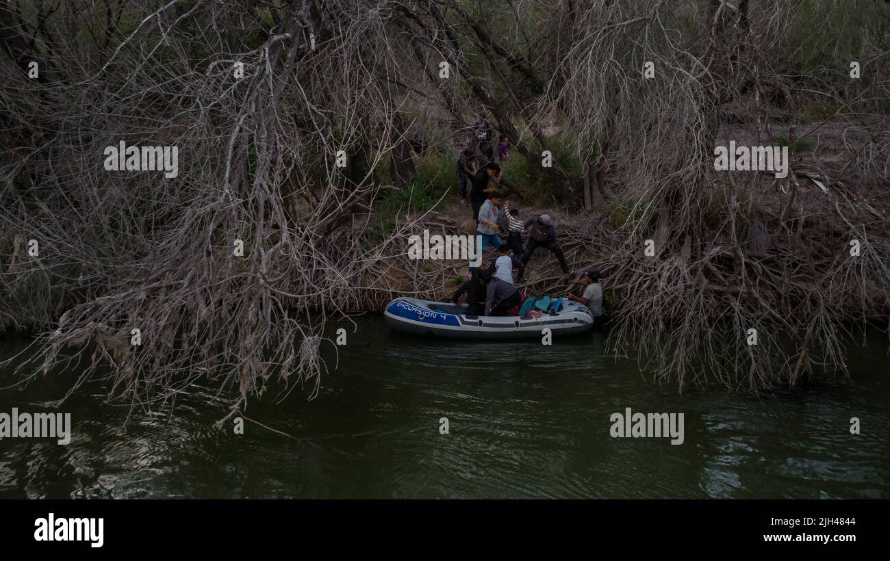 Migrants from Central and South America, looking to surrender to immigration officials, exit a raft after being smuggled across the Rio Grande river into the United States from Mexico in Roma Creek, Texas, U.S., July 14, 2022. REUTERS/Adrees Latif Stock Photo