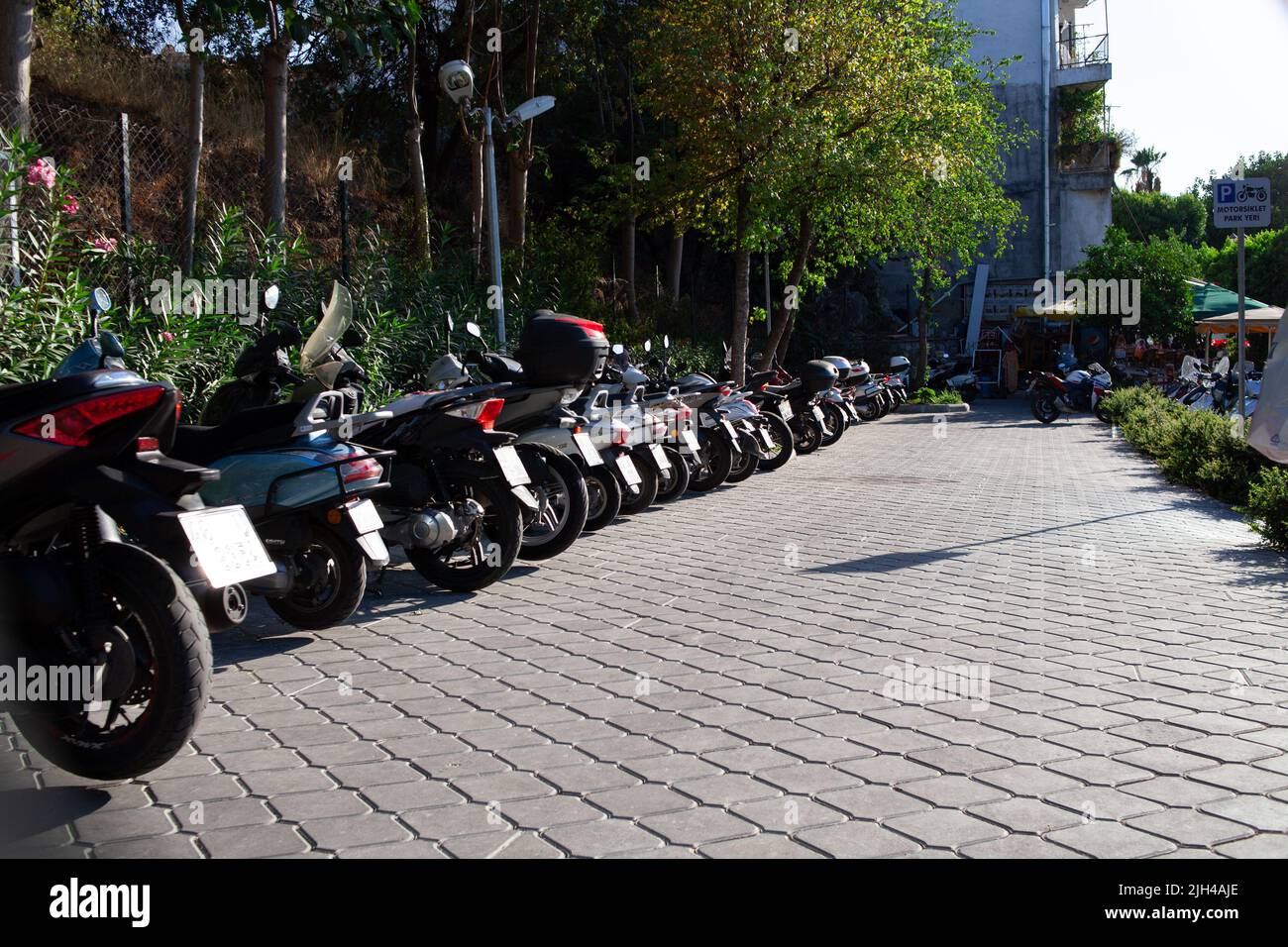 Scooters, motorcycles and mopeds in the street Parking on a Sunny