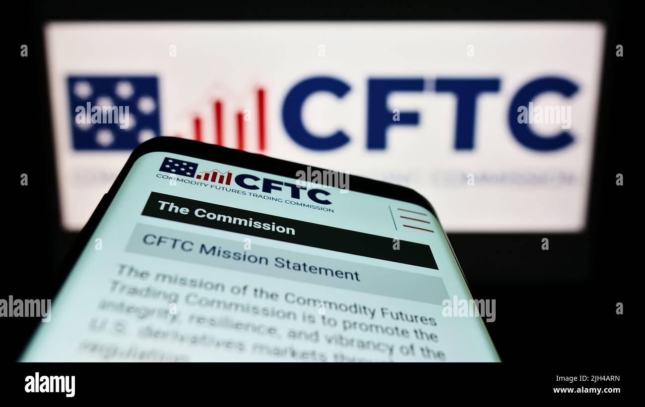 Mobile phone with website of US Commodity Futures Trading Commission (CFTC) on screen in front of logo. Focus on top-left of phone display. Stock Photo