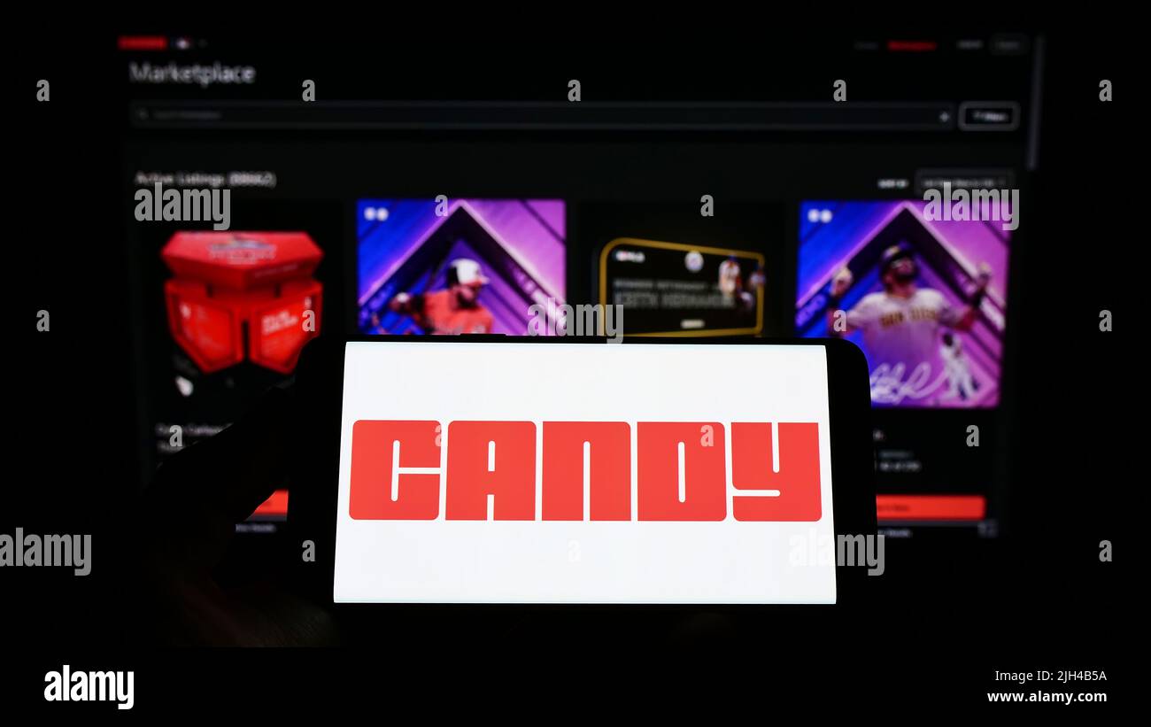 Person holding smartphone with logo of US NFT company Candy Digital on