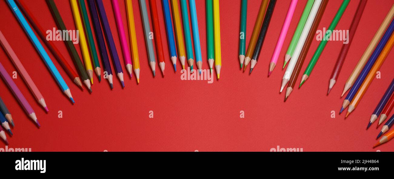 Colored wooden pencils on red background, education concept Stock Photo