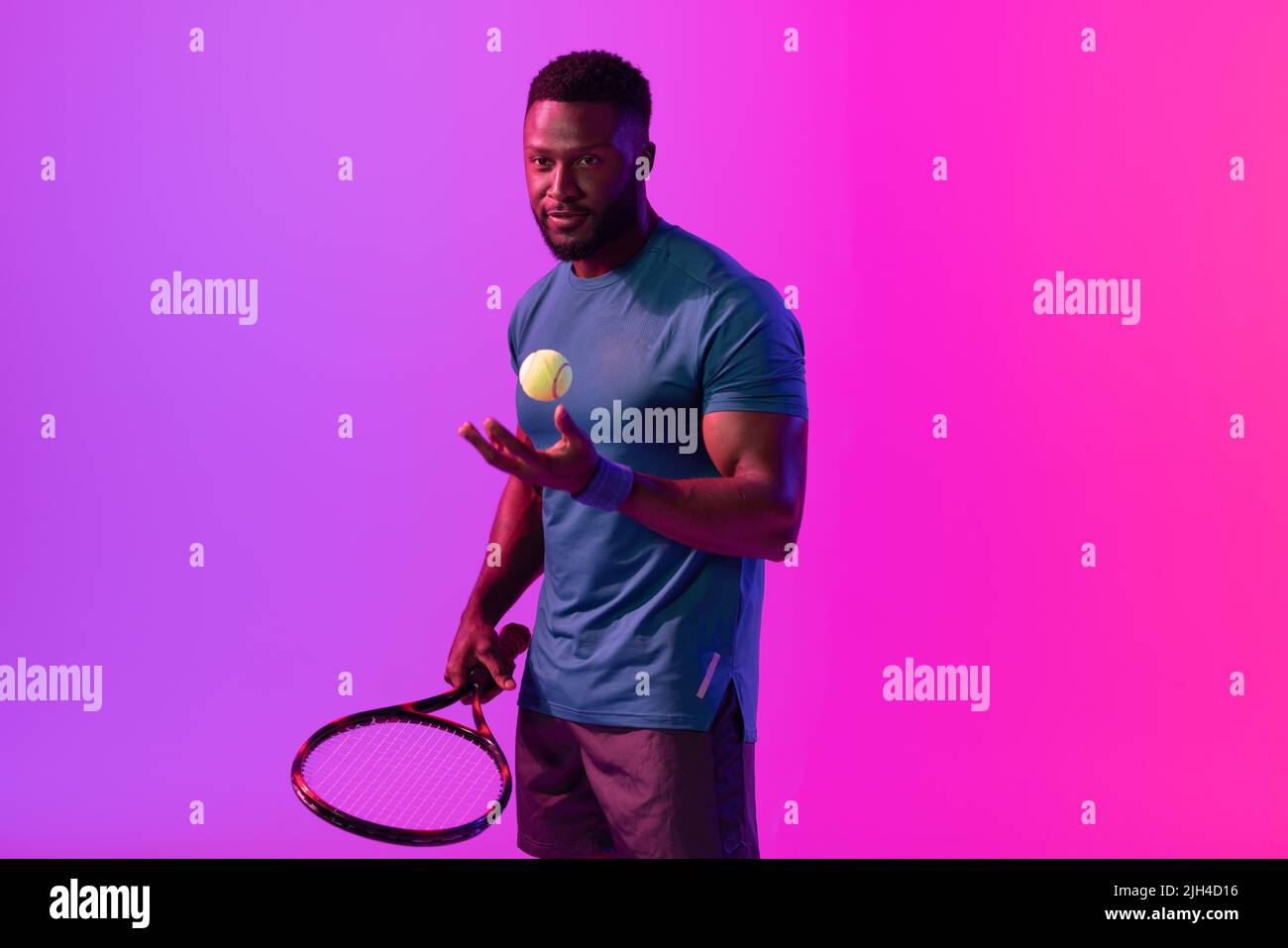 Image of african american male tennis player in violet and pink neon lighting Stock Photo
