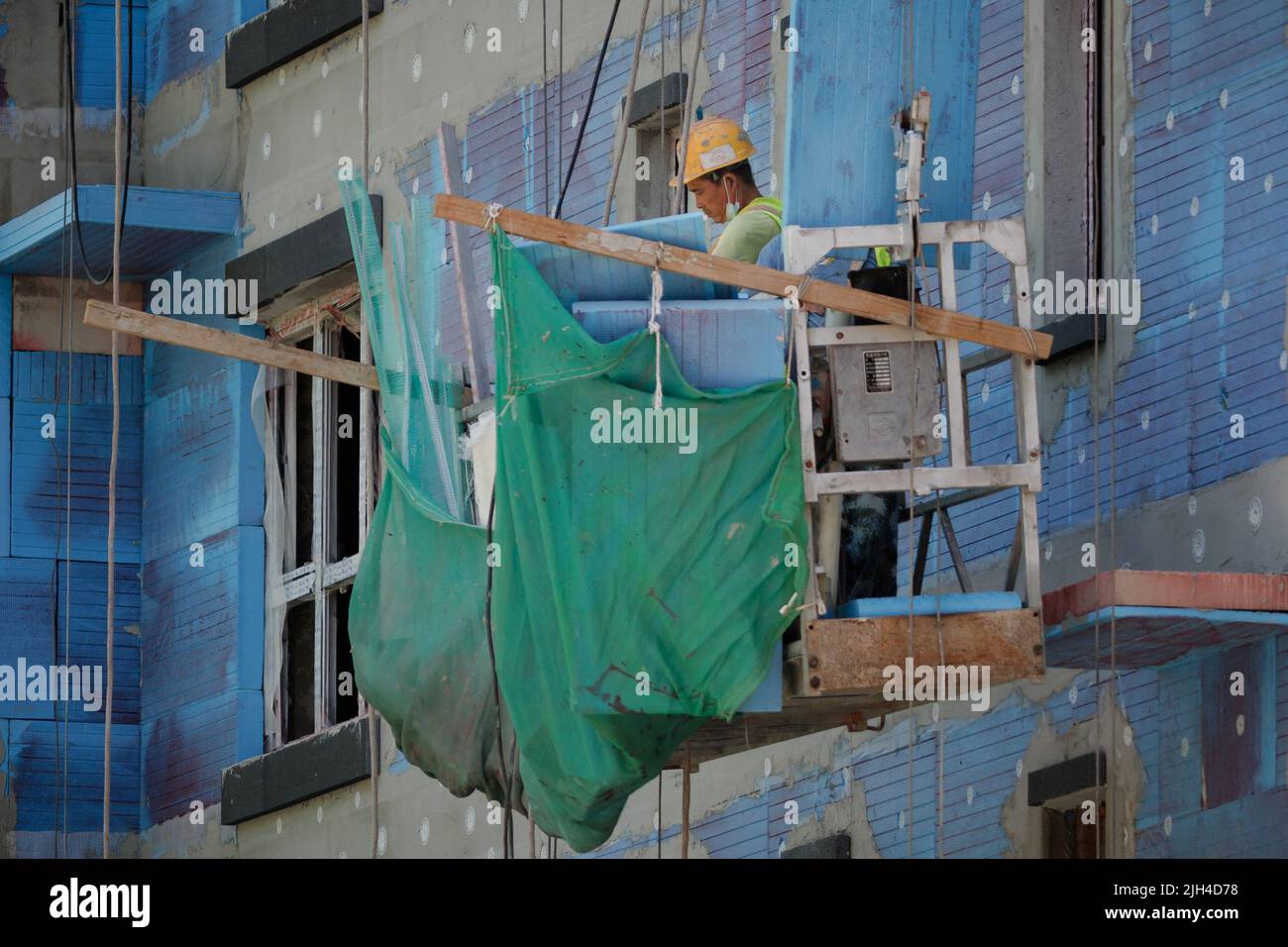 A man works at a construction site of apartment buildings in Beijing, China, July 15, 2022. REUTERS/Thomas Peter Stock Photo