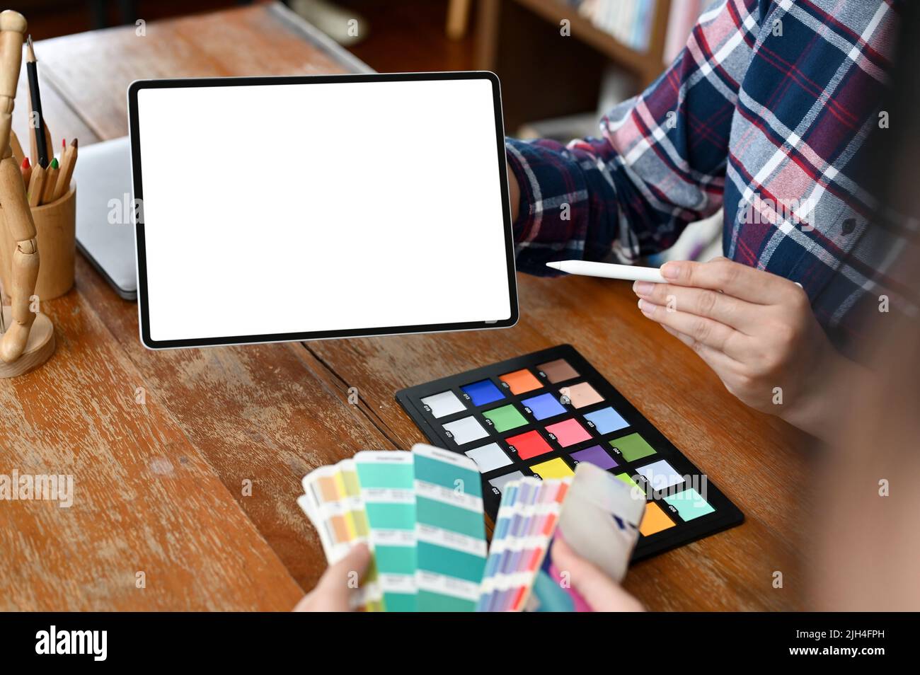 A team of graphic designer having a meeting in the office, A female graphic designer holding a blank tablet touchpad screen. cropped shot Stock Photo