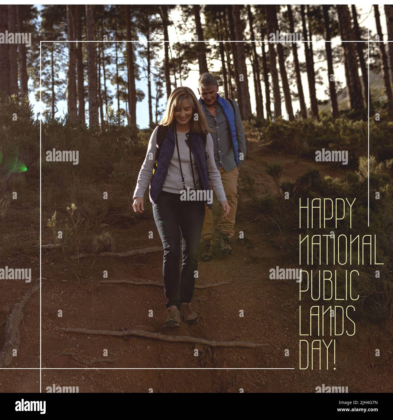Composition of happy national public lands day text with caucasian couple hiking Stock Photo